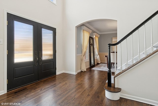 entryway with visible vents, dark wood finished floors, stairs, french doors, and arched walkways