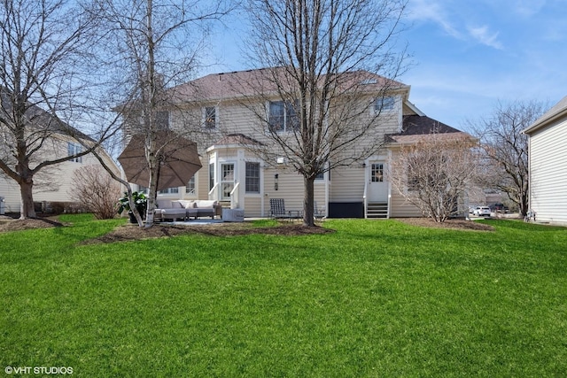 back of property with entry steps and a lawn