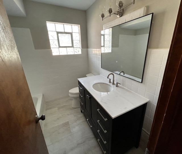 bathroom with toilet, a bath, tile walls, and vanity