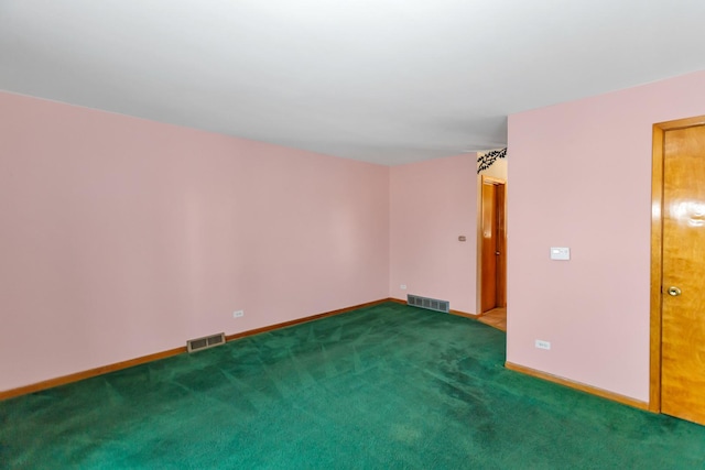 spare room featuring carpet floors, visible vents, and baseboards