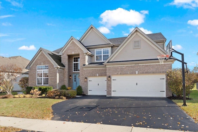 traditional-style home featuring a garage, a front yard, brick siding, and driveway