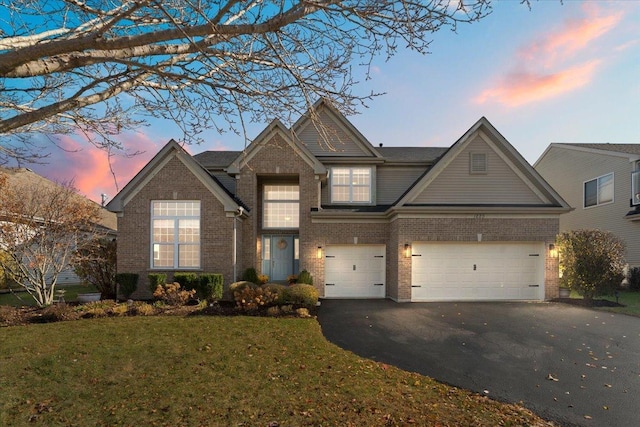 view of front facade featuring driveway, an attached garage, a front lawn, and brick siding