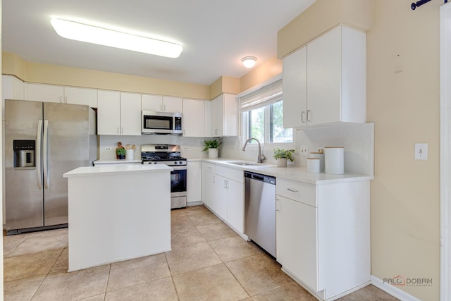 621 Raintree Rd, Buffalo Grove, IL 60089 - kitchen featuring stainless steel appliances, light countertops, white cabinets, a kitchen island, and tasteful backsplash
