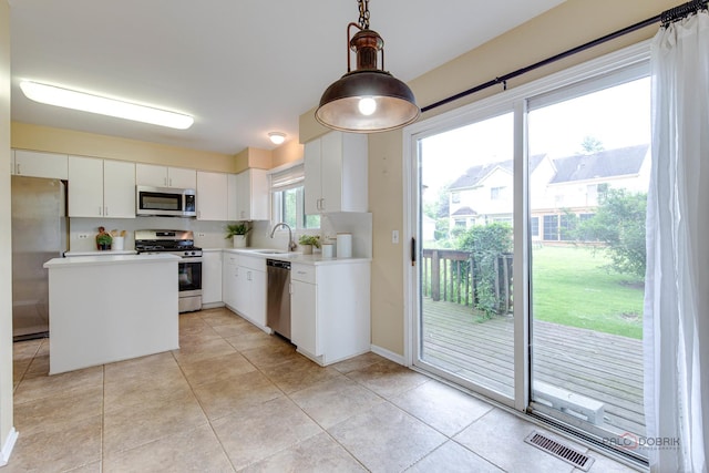 621 Raintree Rd, Buffalo Grove, IL 60089 - kitchen with stainless steel appliances, light countertops, white cabinetry, light tile patterned floors, and hanging light fixtures