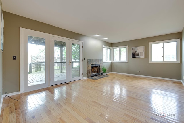 621 Raintree Rd, Buffalo Grove, IL 60089 - unfurnished living room with light wood-type flooring, a tiled fireplace, and french doors