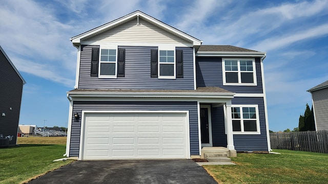 traditional home featuring a garage, aphalt driveway, a front yard, and fence