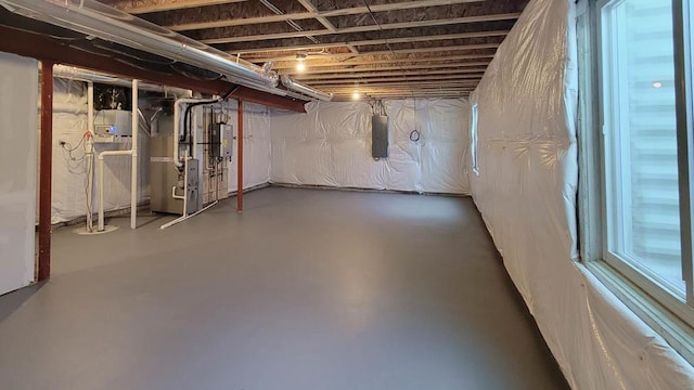 unfinished basement featuring heating unit and electric panel