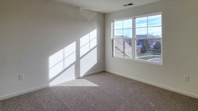 carpeted empty room featuring visible vents and baseboards