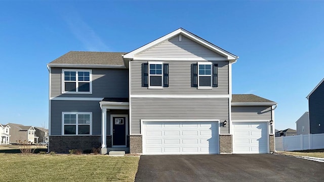 view of front of home with aphalt driveway, a garage, and a front lawn