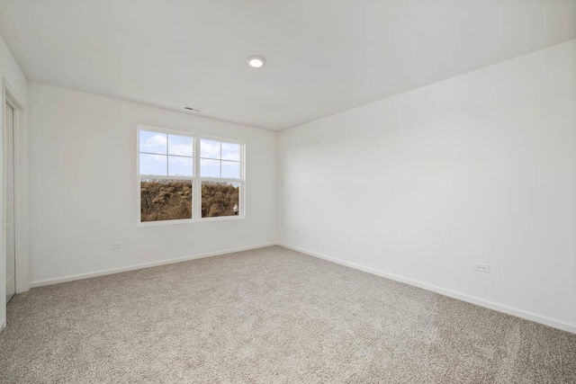 spare room featuring carpet floors and baseboards