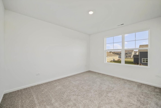 carpeted empty room with visible vents and baseboards