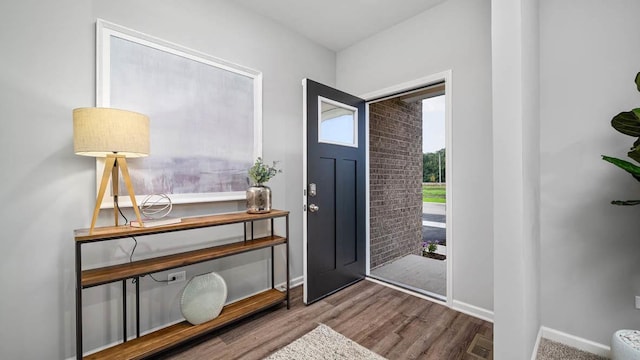 foyer featuring baseboards and wood finished floors