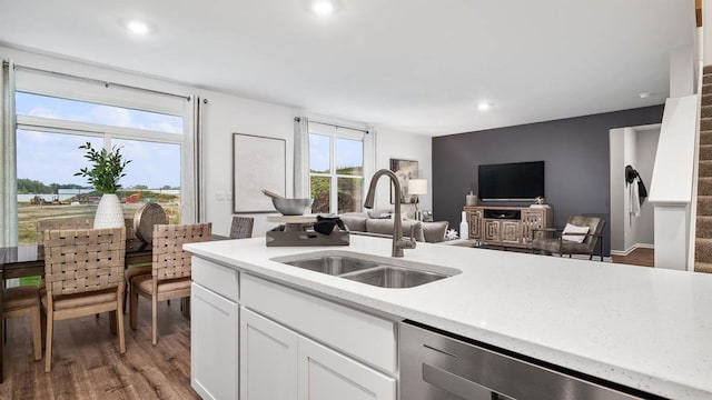 kitchen featuring light countertops, a sink, dishwasher, and white cabinetry