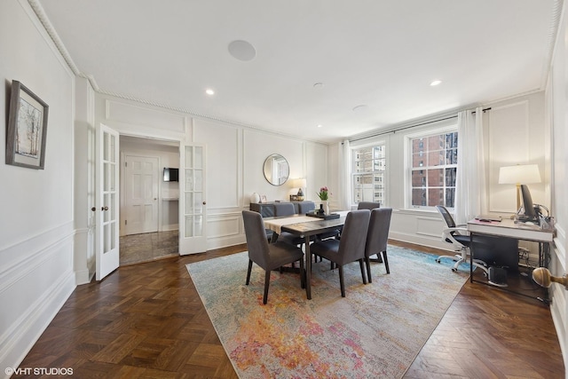 dining space featuring ornamental molding, french doors, recessed lighting, and a decorative wall