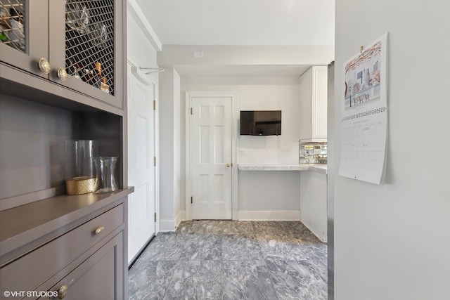 kitchen with light countertops, tasteful backsplash, and baseboards