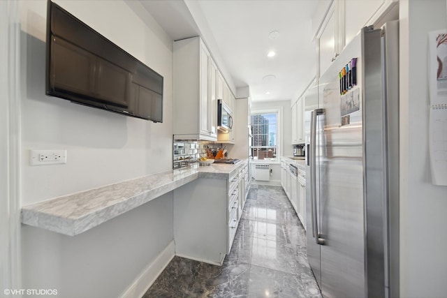 kitchen featuring decorative backsplash, appliances with stainless steel finishes, marble finish floor, white cabinetry, and recessed lighting