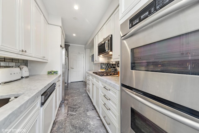 kitchen with tasteful backsplash, white cabinetry, stainless steel appliances, and recessed lighting