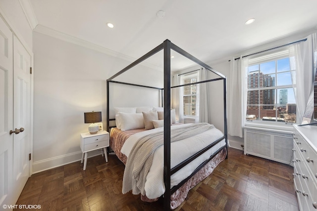 bedroom with a city view, crown molding, recessed lighting, radiator, and baseboards