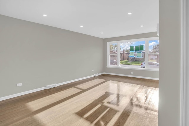 spare room featuring recessed lighting, wood finished floors, visible vents, and baseboards