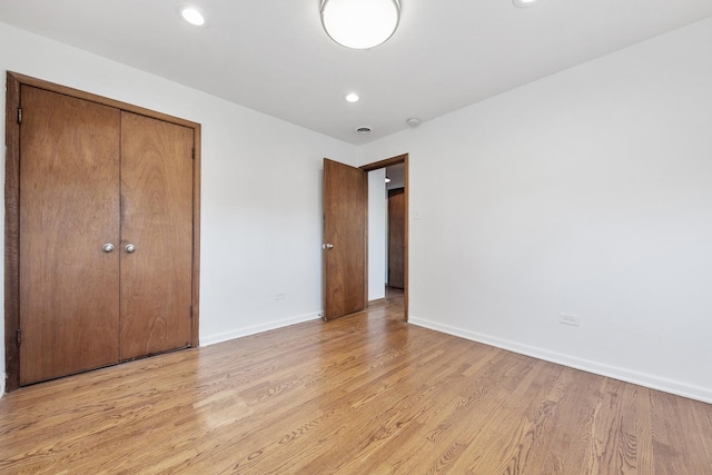 unfurnished bedroom featuring recessed lighting, visible vents, baseboards, a closet, and light wood finished floors