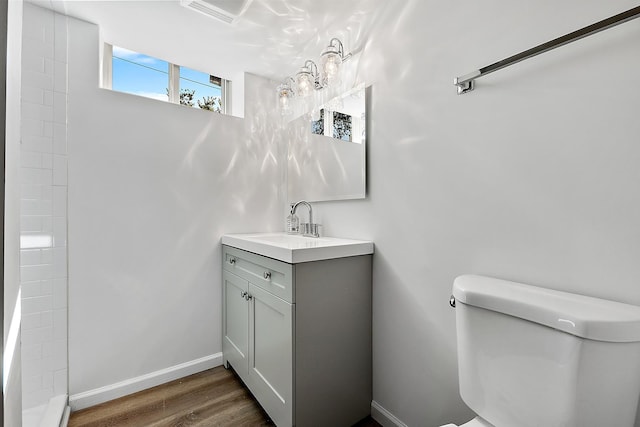 bathroom with vanity, wood finished floors, toilet, and baseboards