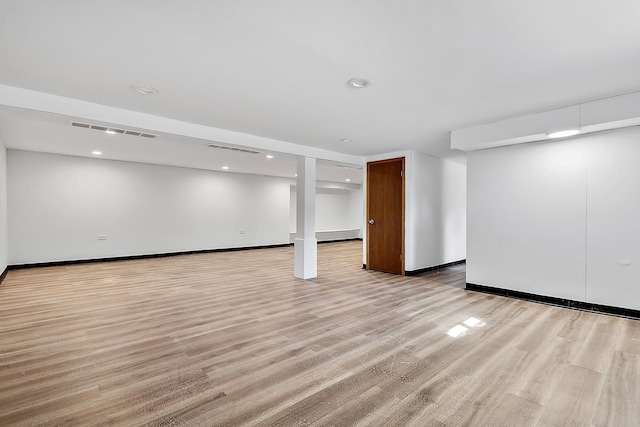 finished below grade area featuring light wood-type flooring, visible vents, and recessed lighting