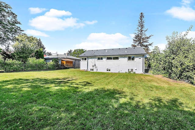 back of house with fence and a yard