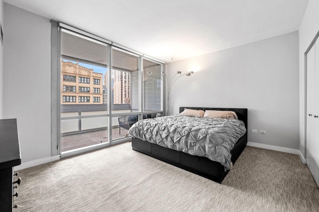 bedroom featuring access to exterior, expansive windows, baseboards, and carpet