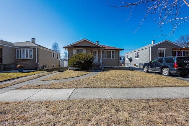 bungalow-style home with a front lawn