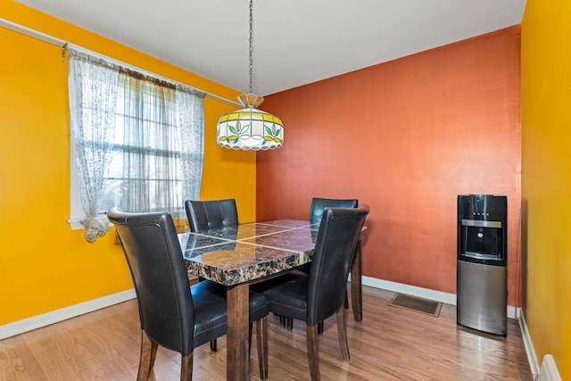 dining room with visible vents, baseboards, and wood finished floors