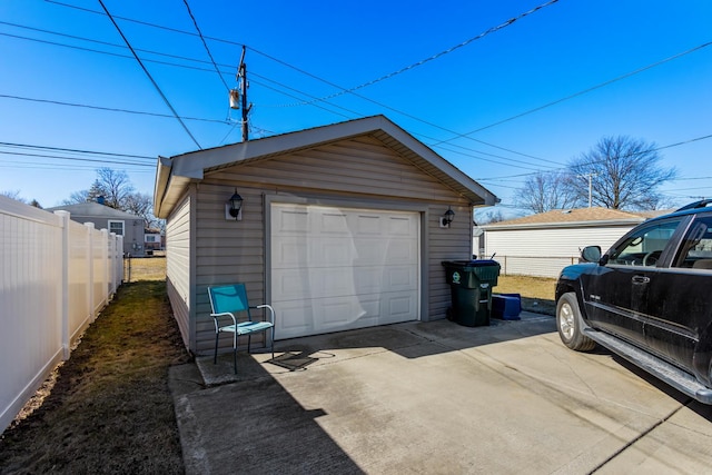 detached garage with driveway and fence