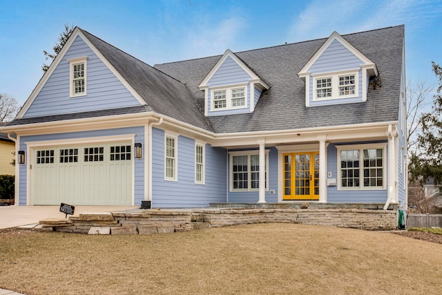 view of front of home featuring a garage, driveway, and a shingled roof