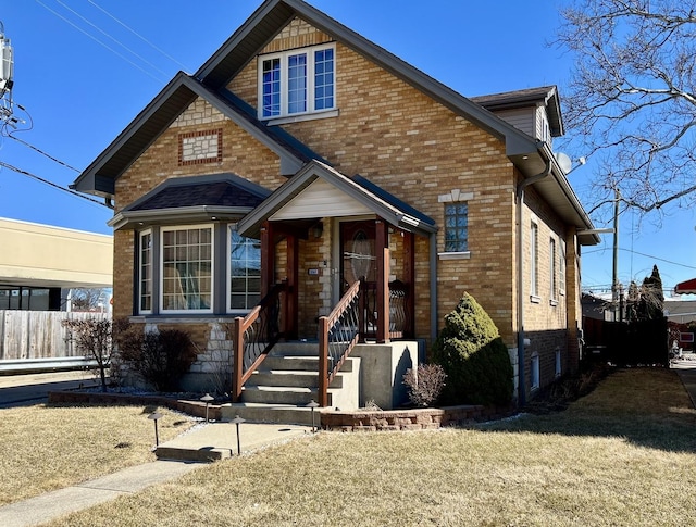 view of front of property featuring fence, a front lawn, and brick siding