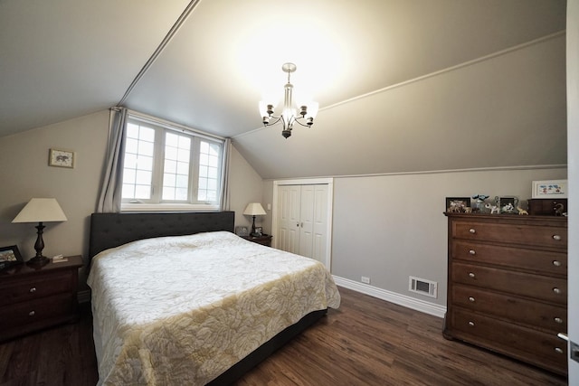 bedroom featuring a chandelier, lofted ceiling, visible vents, a closet, and dark wood-style floors