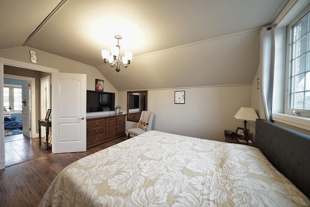 bedroom featuring lofted ceiling, dark wood-style flooring, and an inviting chandelier