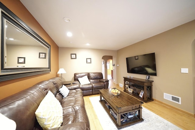 living room featuring arched walkways, recessed lighting, visible vents, wood finished floors, and baseboards