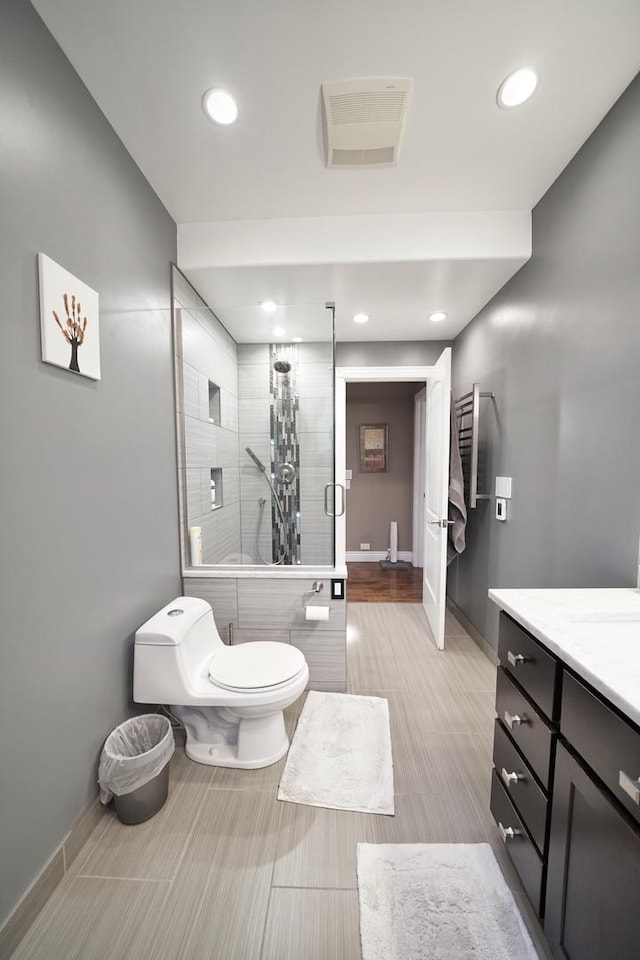 bathroom featuring visible vents, toilet, a shower stall, vanity, and baseboards