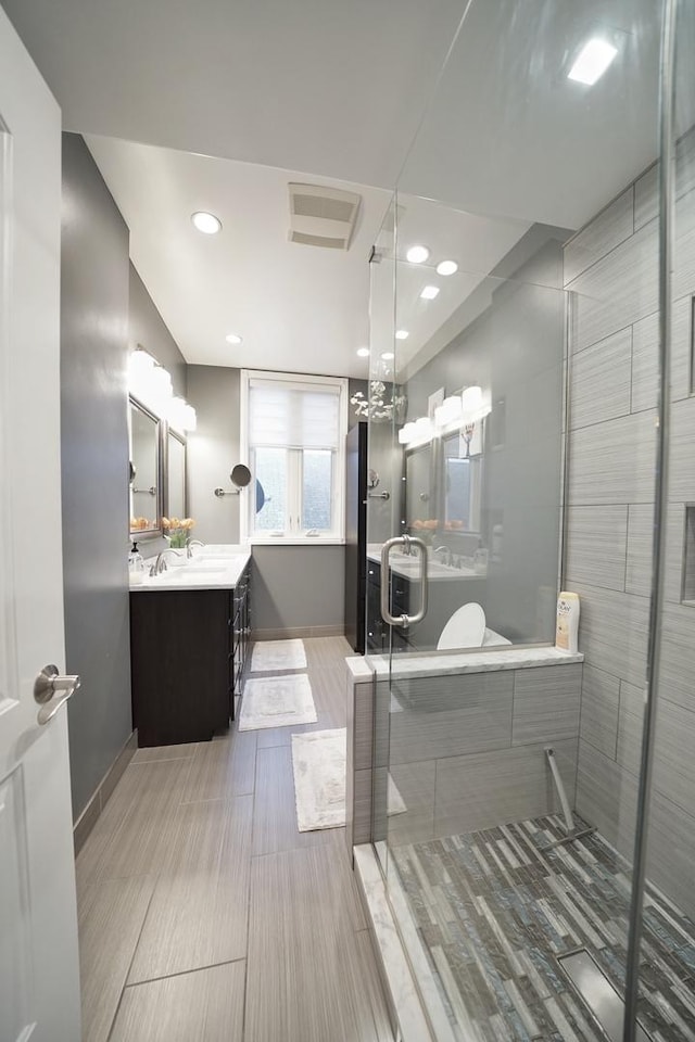 bathroom featuring a stall shower, visible vents, vanity, and recessed lighting