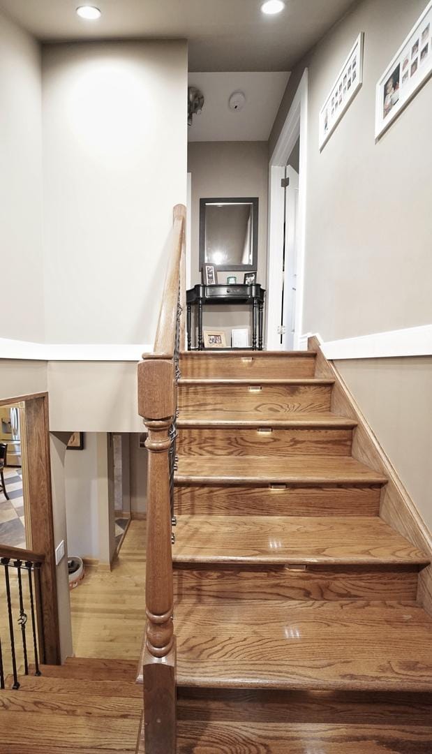 stairway featuring wood finished floors and recessed lighting