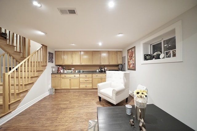 kitchen with light wood finished floors, recessed lighting, dark countertops, visible vents, and light brown cabinetry