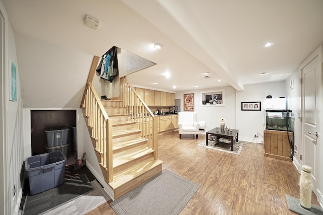 stairs with baseboards, beamed ceiling, wood finished floors, and recessed lighting