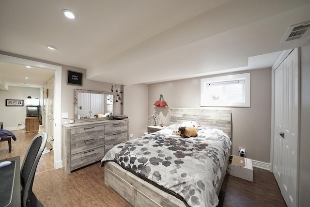 bedroom with visible vents, baseboards, wood finished floors, a closet, and recessed lighting