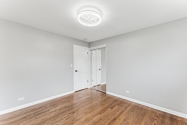 unfurnished room with wood finished floors and baseboards
