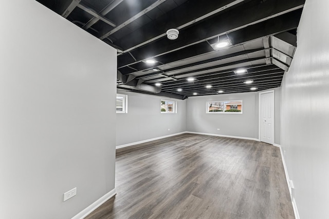 below grade area featuring baseboards and wood finished floors
