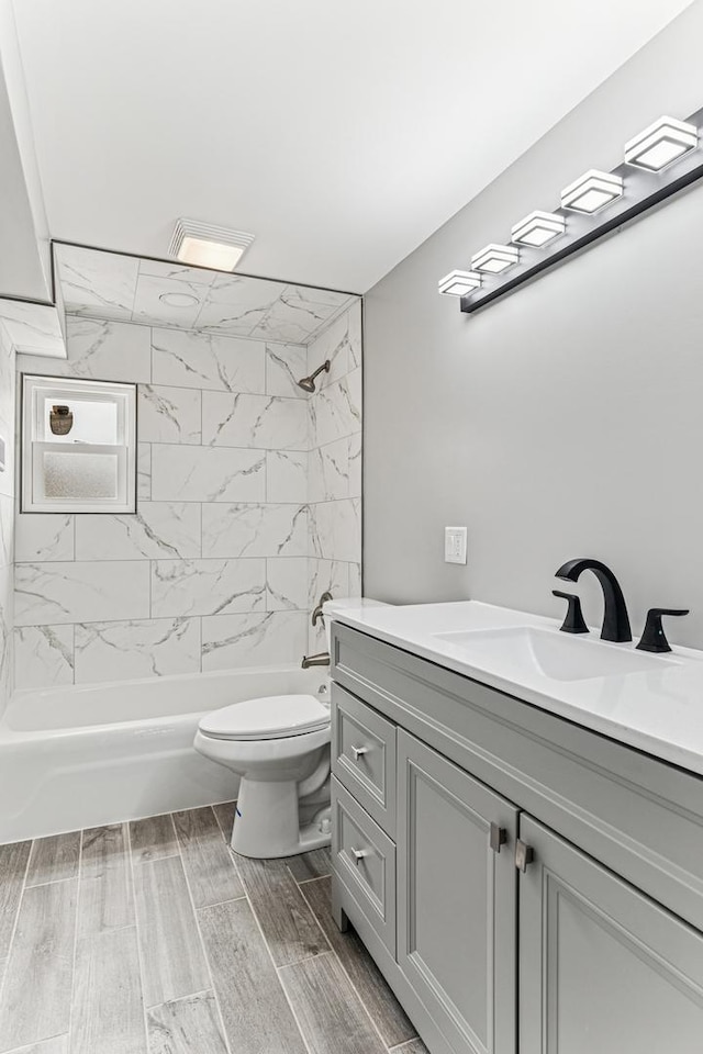bathroom featuring toilet, vanity, and shower / washtub combination