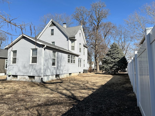 view of side of property featuring fence and a chimney