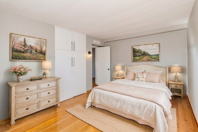 bedroom featuring light wood-style floors, a closet, and visible vents