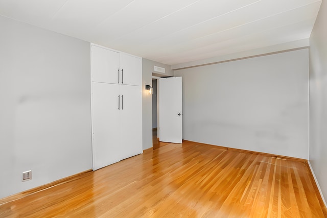 unfurnished bedroom featuring light wood-style flooring and a closet