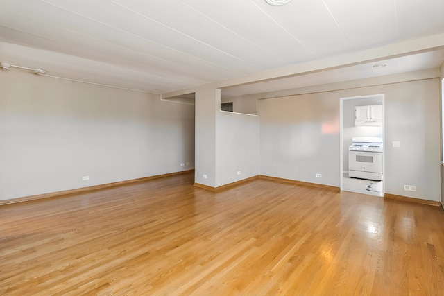 unfurnished room with light wood-style flooring and baseboards