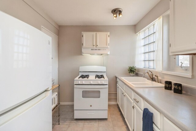 kitchen with white cabinetry, a sink, light tile patterned flooring, white appliances, and under cabinet range hood